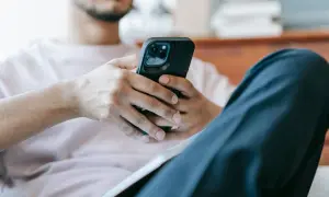 Mężczyzna z telefonem w dłoniach. Zastanawia się, jak sprawdzić czy ktoś mnie zablokował na Messengerze.