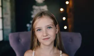 Uśmiechnięta dziewczynka z niebieskimi oczami, która mogłaby czerpać korzyści z kolagenu dla dzieci.