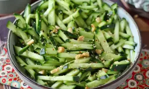 Una fresca insalata di cetrioli tagliati a julienne, condita con semi di sesamo, arachidi e peperoncino.