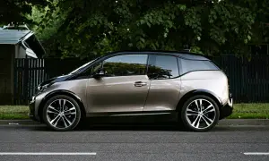 En BMW i3 står parkerad vid en grönskande trädgård. Kanske ett problem med laddningen?