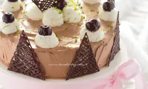 Deliziosa torta **foresta nera dolce** con panna montata, ciliegie e decorazioni di cioccolato.