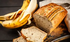 Pyszny chlebek bananowy, idealny pomysł, co zrobić z bananów. Obok leżą świeże banany.