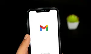 Dłoń trzyma smartfon z logo Gmail. Chcesz wiedzieć, jak wylogować się z Gmail? Ten obrazek pokazuje ekran startowy aplikacji.