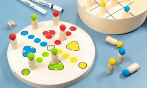 Holzfiguren und Würfel für selbst gebastelte Spiele. Ein Spielbrett mit bunten Feldern und ein Tic-Tac-Toe-Spiel laden zum Spielen ein.