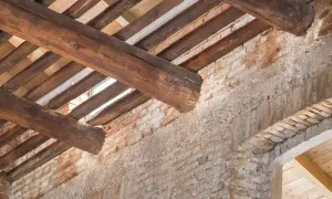 Trave in legno deteriorate e mattoni a vista: segnali evidenti per capire se un tetto è da rifare.