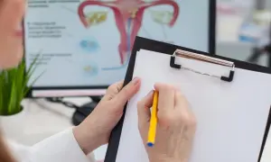Lekarz omawia z pacjentką, co to cytologia, analizując wyniki na ekranie z anatomią układu rozrodczego.