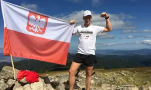 Zdobywca Korony Polskich Gór z biało-czerwoną flagą na szczycie.