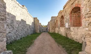 Kamienne mury i łuki zamku Tenczyn w Rudnie tworzą malowniczą ścieżkę.