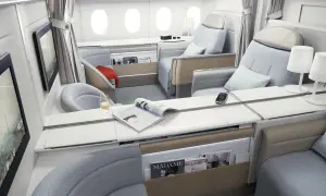 Luxuriöse Sitze in der **first class** eines Flugzeugs, mit Magazinen, einem Glas Wein und Bildschirmen.