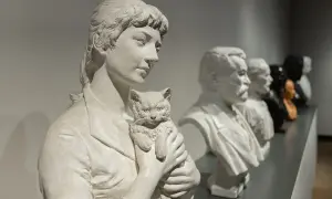 Rzeźba Camille Claudel "Plotkarki" - kobieta z kotem, obok popiersia mężczyzn.