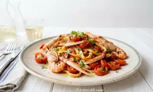 Un piatto invitante di linguine agli scampi, condite con pomodorini succosi e basilico fresco.