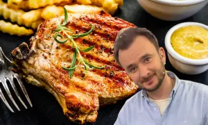 Pyszny schab z kością, grillowany z rozmarynem, podany z frytkami i musztardą. Uśmiechnięty mężczyzna w tle.