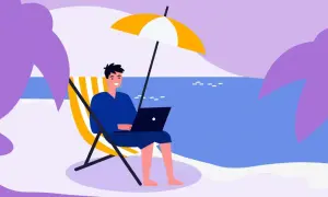 Mężczyzna pracuje na laptopie na plaży pod parasolem. Idealne miejsce na urlop, od kiedy 35 dni urlopu to norma.