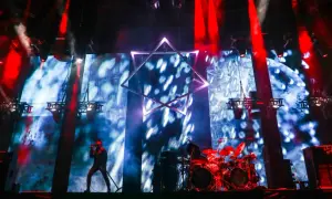 Wokalista na scenie, perkusja, wielka gwiazda na tle ekranu. Niesamowita atmosfera na **impact festival**.