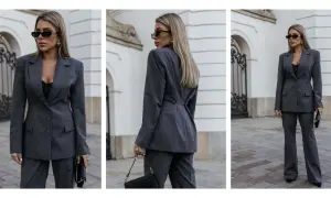 Elegancka kobieta w szarym garniturze, prezentująca styl minimalistyczny ubiór. Czarna koronkowa bluzka i okulary dodają charakteru.