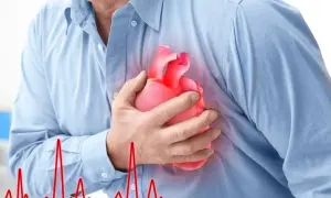 Mężczyzna trzyma dłoń na piersi, gdzie widnieje symbol serca. Obok widnieje wykres EKG, sugerujący **częstoskurcz napadowy**.