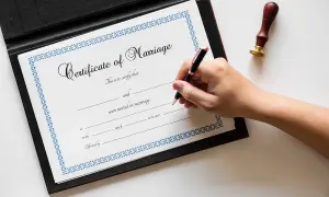 Podpisanie aktu małżeństwa. Dokument "Certificate of Marriage" z pieczęcią i piórem.