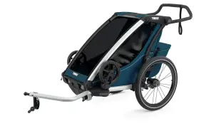En blå Thule Chariot Lite barnvagn med silverdetaljer och stora hjul, redo för äventyr.