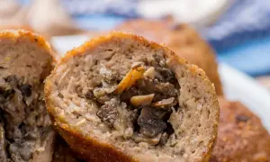 Kotlety mielone z pieczarkami, przekrojone na pół, ukazujące soczyste nadzienie z grzybów.