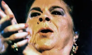 Primer plano de una mujer con maquillaje dramático, labios entreabiertos y mano levantada. Se especula de que murió la Paquera de Jerez.