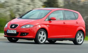 Czerwony Seat Altea 1.6 benzyna w ruchu, z rozmytym tłem.