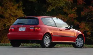 Czerwony Honda Civic Si z lat 90. na tle jesiennych drzew.