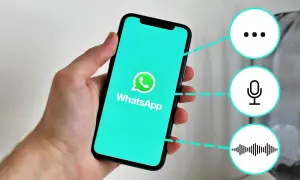 Mano sostiene un teléfono con WhatsApp. Iconos de puntos suspensivos, micrófono y onda sonora sugieren funciones, como "que significa gn en inglés".
