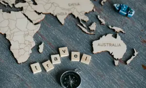 Drewniana mapa świata z napisem "AUSTRALIA" i literami "travel". Ciekawe ciekawostki o Australii czekają na odkrycie!
