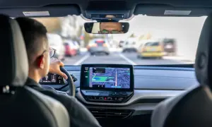 Navigazione con Android Auto Wireless su un'auto moderna. Il conducente segue il percorso sullo schermo centrale, godendosi la comodità senza fili.