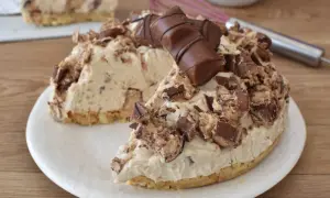 Una golosa torta kinder bueno, con crema e pezzi di cioccolato, su un piatto bianco.