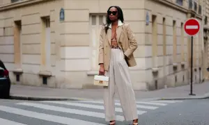 Eine Frau in beiger Marlenehose und Blazer, die einen stilvollen Look kreiert.