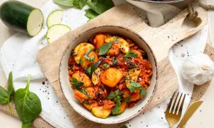 Gnocchi mit Spinat und Zucchini in Tomatensauce, garniert mit schwarzen Sesam.