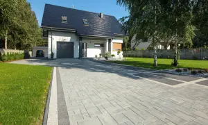 Nowoczesny dom z garażem i pięknym podjazdem z kostki granitowej.