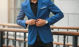 Mann im blauen Anzug und schwarzem Hemd, der seinen Anzug zuknöpft. Elegante Kleidung für einen besonderen Anlass.