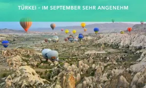 Heißluftballons steigen über die Felsformationen von Kappadokien auf. Perfekt für Backpacking im September.