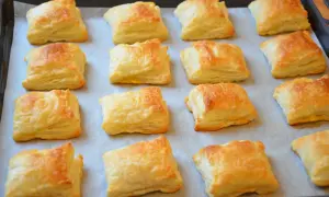 Pieczone kwadratowe ciastka francuskie na blasze.
