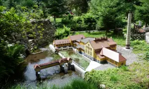 Miniaturowa zabudowa z mostkiem i rzeką, część największego parku miniatur w Polsce.