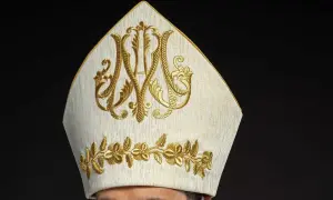 Biała mitra z haftem w kolorze złota, symbolizująca godność. Warto wiedzieć, jak się zwracać do biskupa, by okazać mu szacunek.