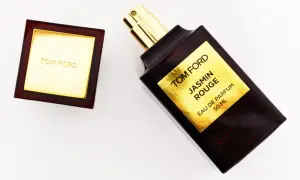 Elegancka butelka perfum Tom Ford Jasmin Rouge z złotą etykietą i korkiem.