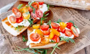 Geröstetes Brot mit Burrata, Kirschtomaten und Rucola.