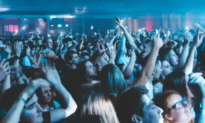 Tłum na innej polskiej imprezie, ludzie z rękami w górze, światła klubowe.