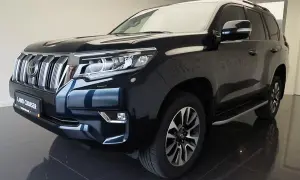 Ciemnogranatowy Land Cruiser Prado z chromowanym grillem i reflektorami LED, gotowy na każdą przygodę.