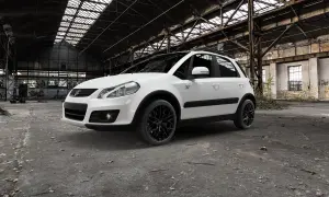Vit Suzuki SX4 med svarta fälgar står i en övergiven lagerlokal. Kanske ett problem med att hitta en ny ägare?