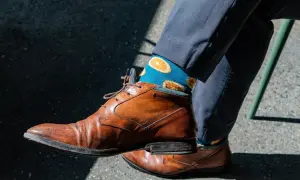 Niebieskie skarpetki w pomarańcze dodają charakteru do eleganckiego garnituru. Idealne pytanie: jakie skarpetki do garnituru?