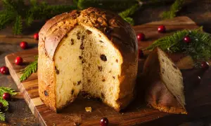 Ein köstlicher Panettone, perfekt für ein sizilianisches Panettone Rezept, mit Rosinen und Nüssen, dekoriert mit Cranberries und Tannenzweigen.