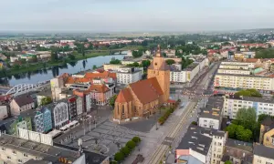 Gorzów Wielkopolski atrakcje dla dzieci: malowniczy widok na miasto z rzeką, kościołem i kolorowymi kamienicami. Idealne miejsce na rodzinne wycieczki.