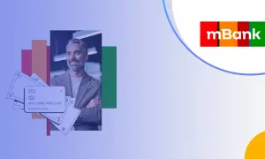 Uśmiechnięty mężczyzna z kartą i pieniędzmi, symbolizujący korzyści z mKonto Intensive. Opłaty są przejrzyste.