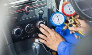 Mechanik sprawdza, ile czynnika do klimatyzacji pozostało w samochodzie, używając manometrów.