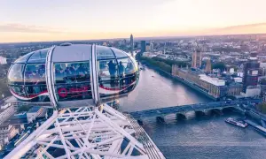 Widok z kapsuły London Eye na Tamizę i Parlament. Ludzie podziwiają panoramę Londynu o zachodzie słońca.