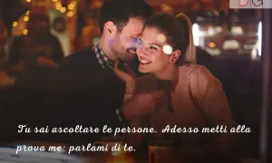 Coppia in un locale con luci soffuse. Lei sussurra a lui, cercando le parole giuste per far innamorare un uomo.